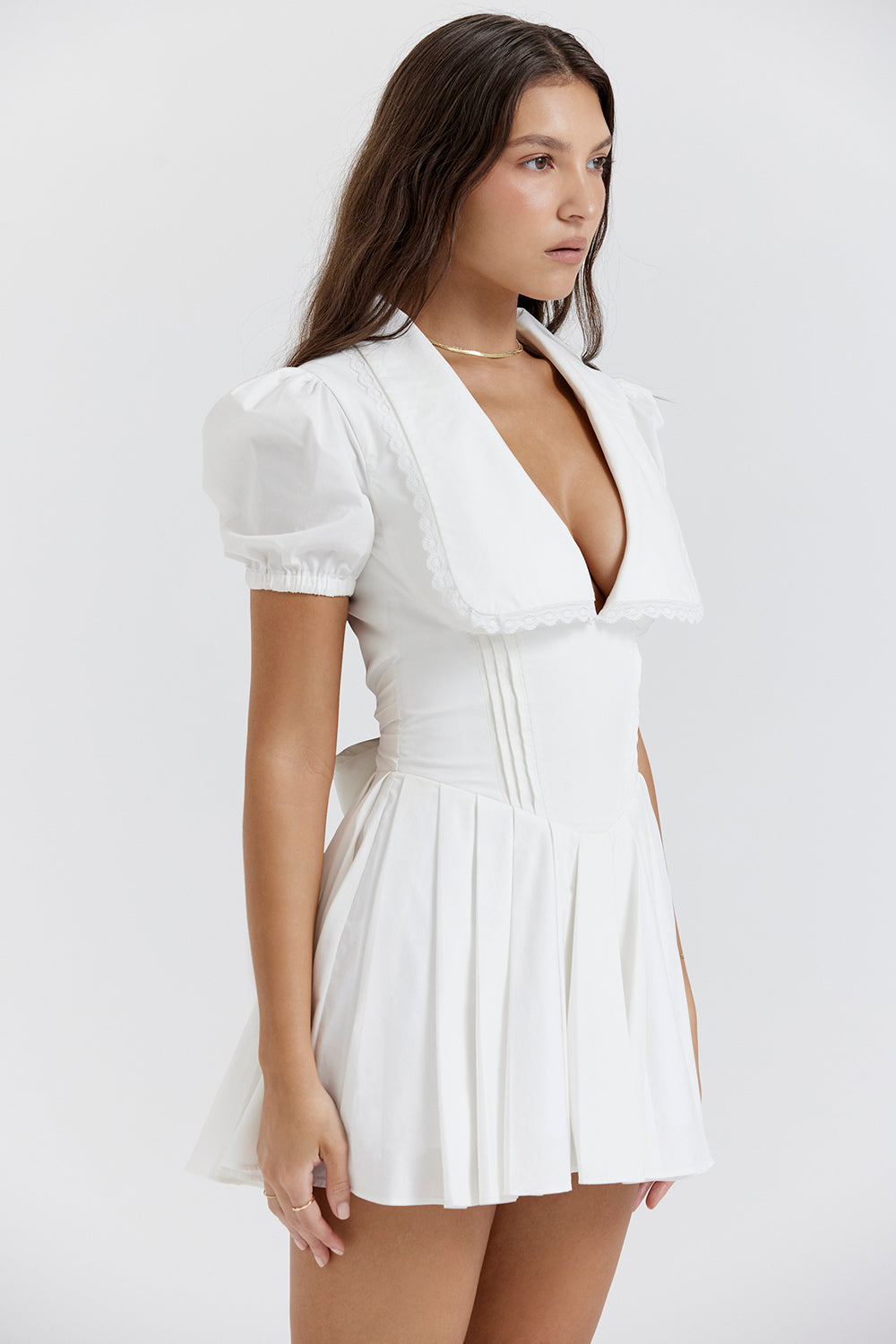 White mini dress with V-neck and pleated skirt side profile