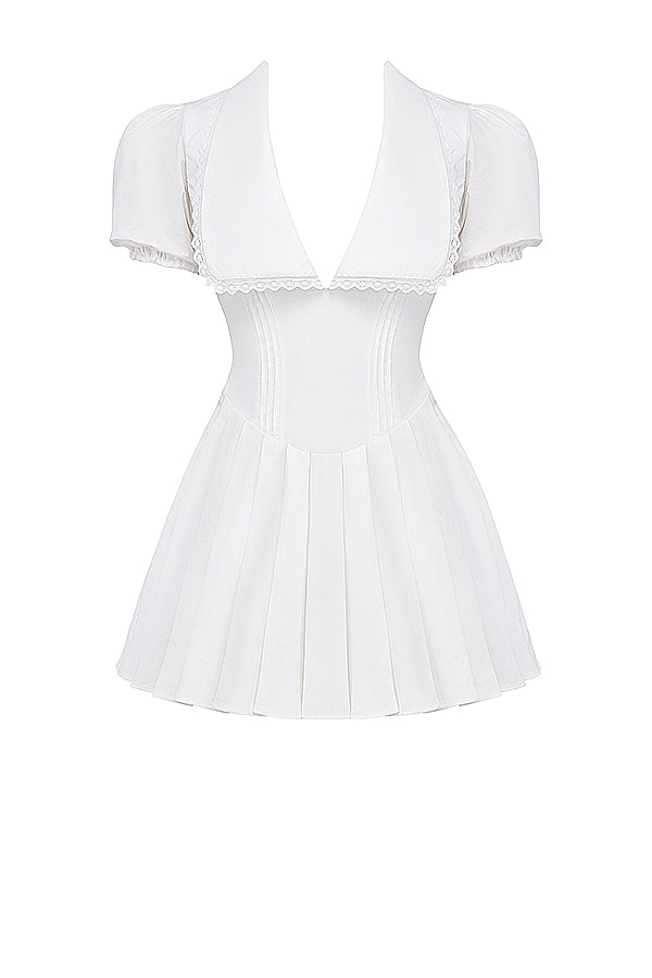 White mini dress with V-neck and pleated skirt isolated front view