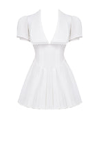 White mini dress with V-neck and pleated skirt isolated front view