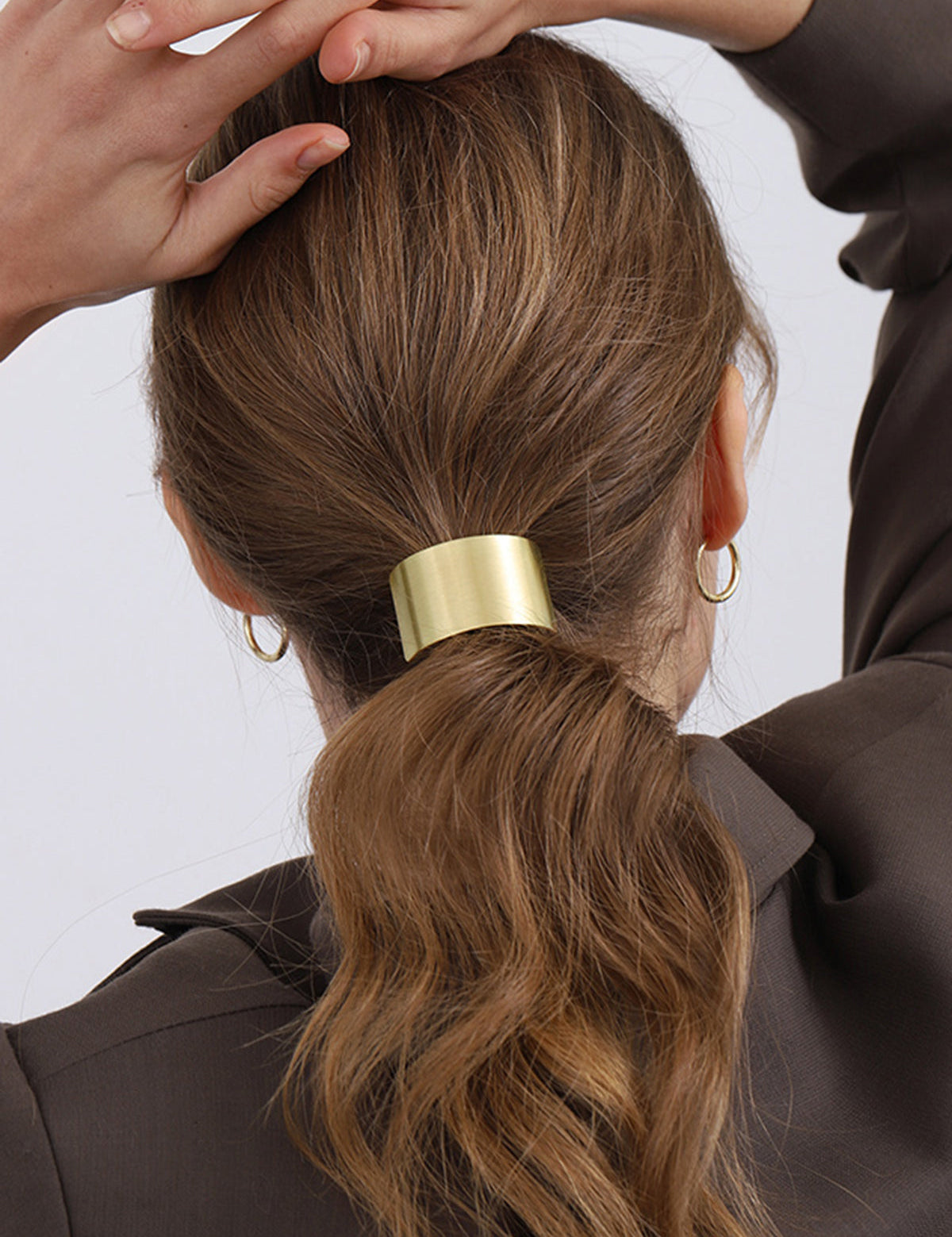 Gold metal hair cuff worn on ponytail, side view