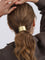 Gold metal hair cuff worn on ponytail, side view