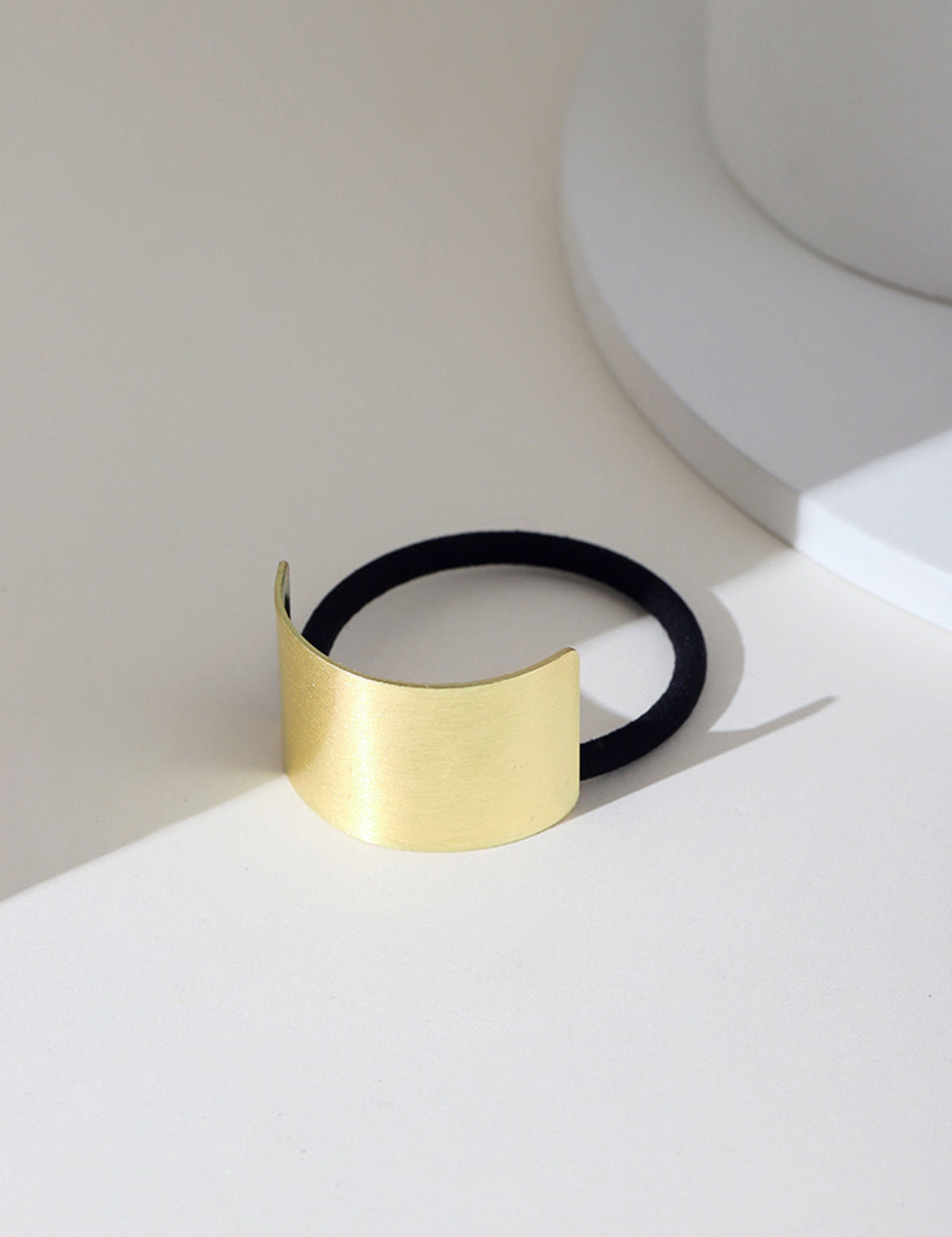 Gold metal hair cuff with black elastic, front view
