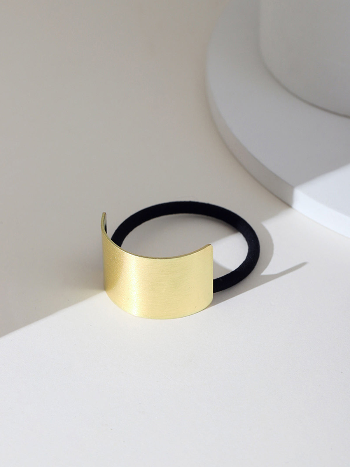 Gold metal hair cuff with black elastic, front view