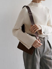 Cream sweater with balloon sleeves and ribbed texture, worn with crossbody bag