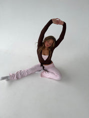 Brown wrap top with pink pants seated stretch