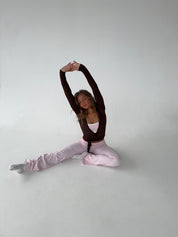 Brown wrap top with pink pants seated stretch