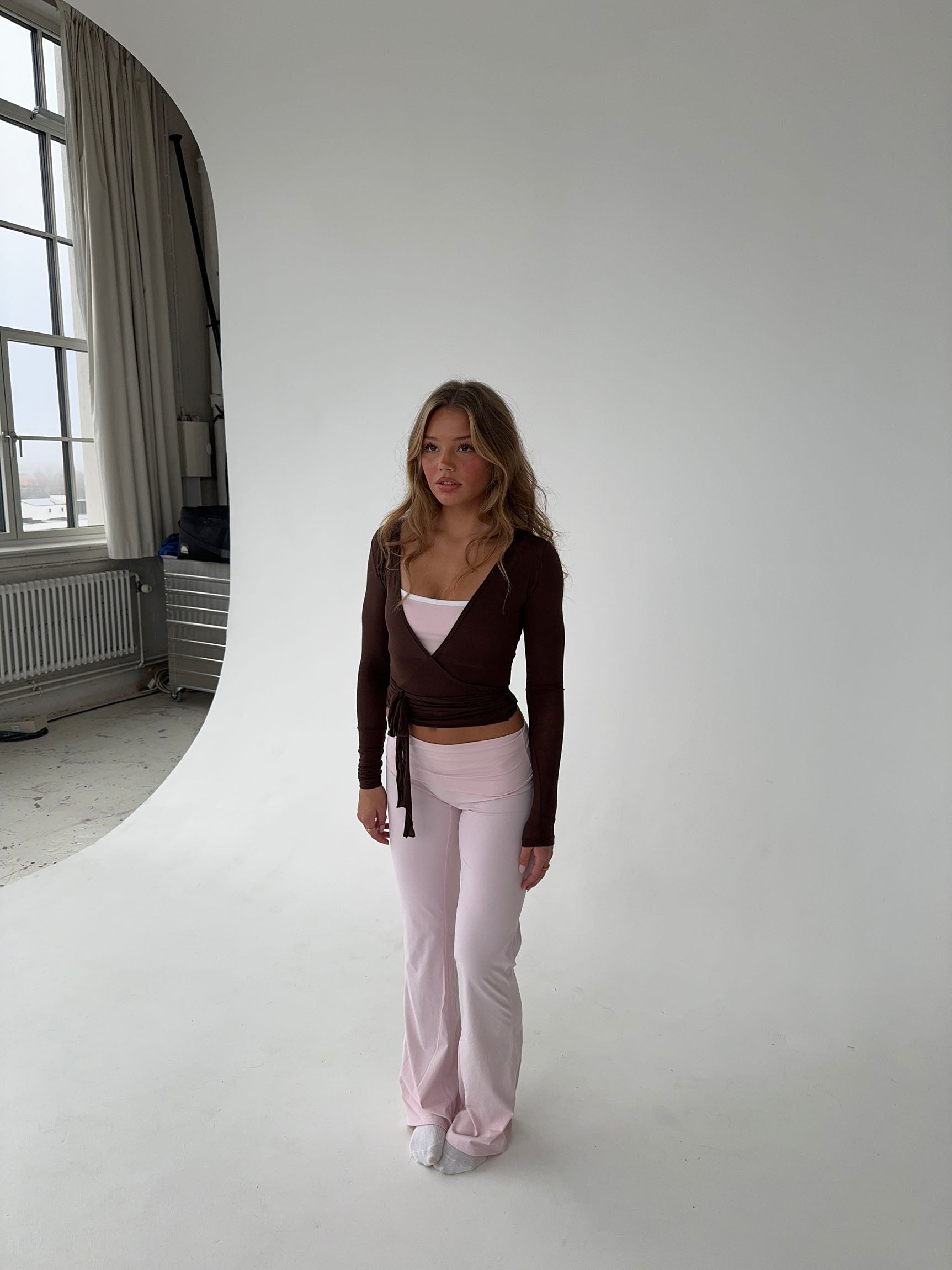 Brown wrap top with pink pants studio pose