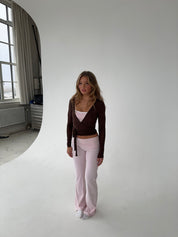 Brown wrap top with pink pants studio pose