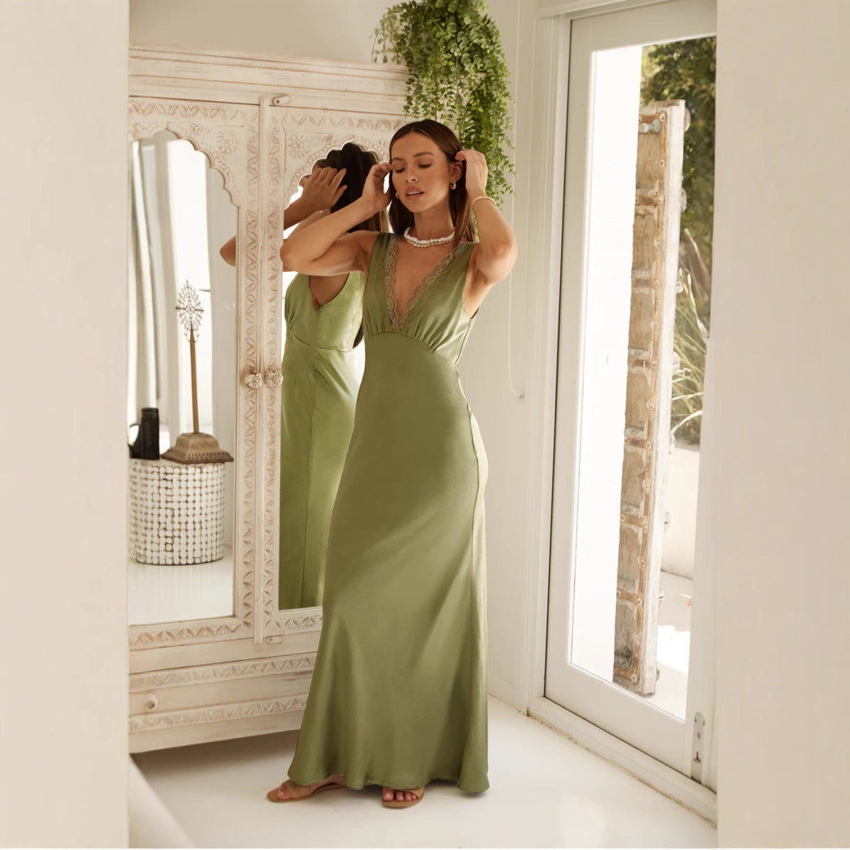 Maxi dress with V-neck and lace trim model adjusting hair