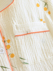 Pyjama set wit met gele bloemenprint en oranje details detail shot