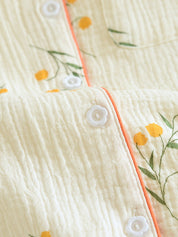 Pyjama set wit met gele bloemenprint en oranje rand detail shot