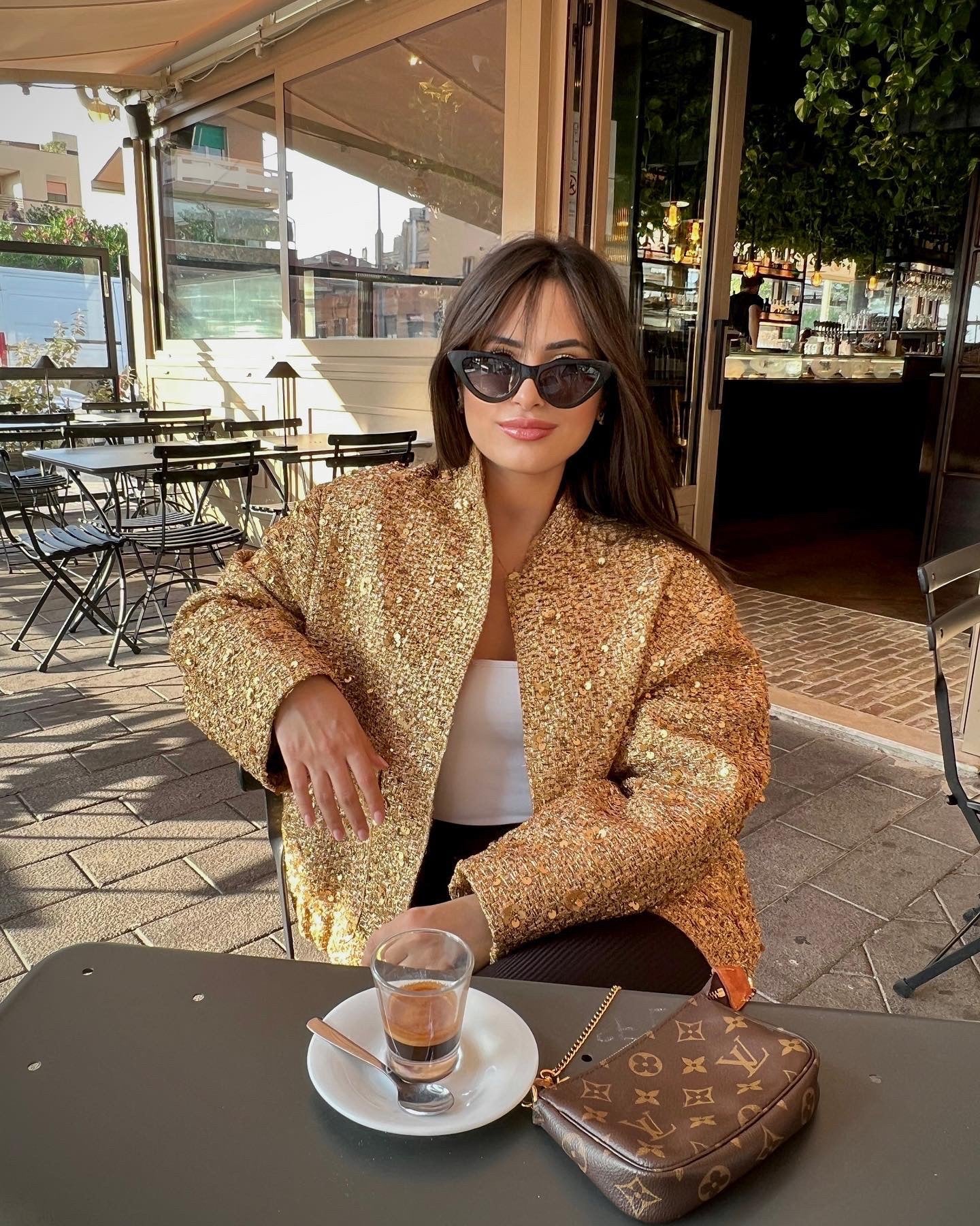 Jas goud met pailletten, vrouw zittend in café