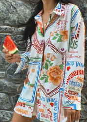 Two-piece set with colorful tropical print, holding watermelon