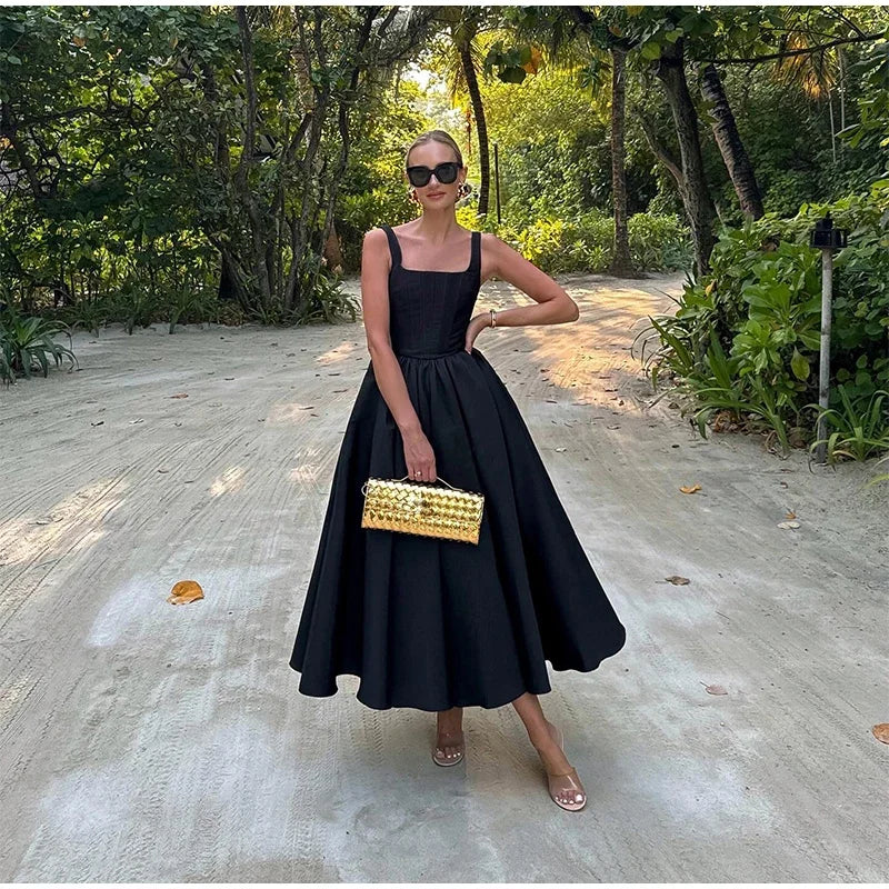 Black fit-and-flare dress front view on model outdoors