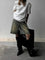 White t-shirt with glittery rhinestones worn with denim shorts and black boots, side view