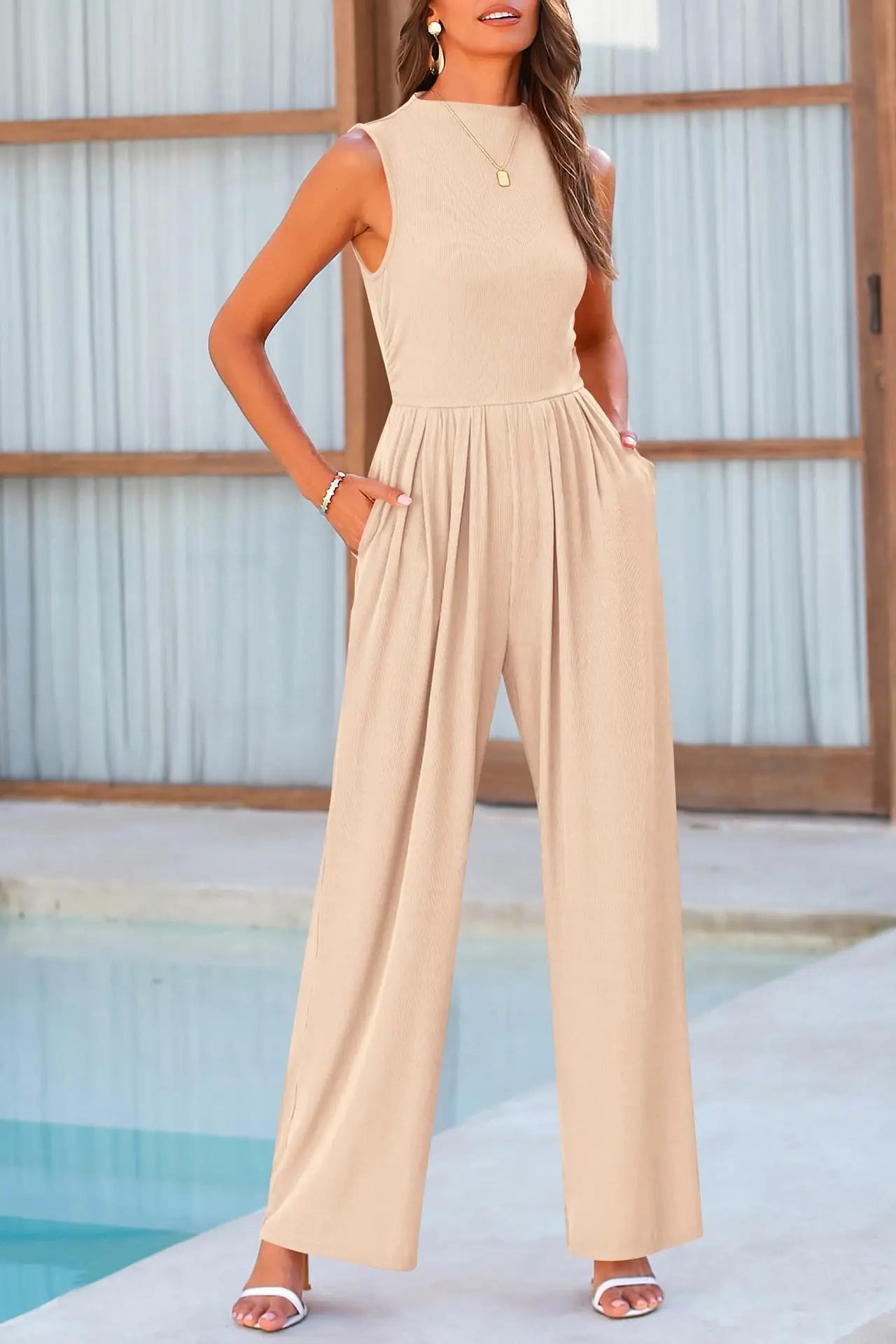 Beige jumpsuit with wide legs, model wearing by pool