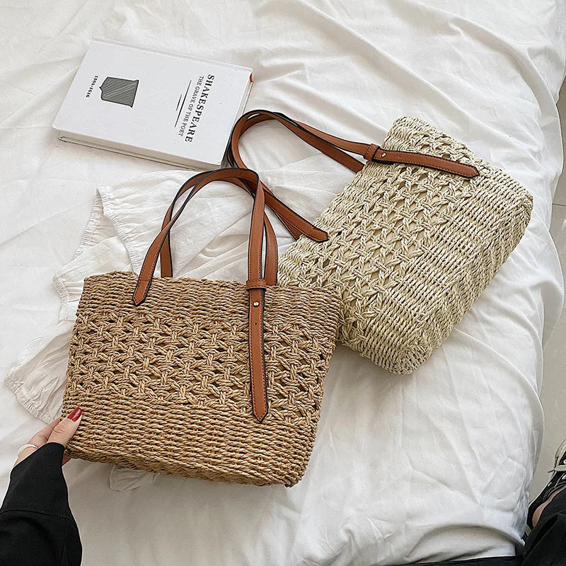 Woven straw tote bag with brown leather handles, overhead view on bed