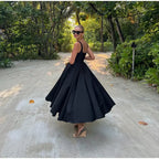Black fit-and-flare dress back view on model outdoors