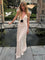 White maxi dress with deep V-neck and black bow front view by water