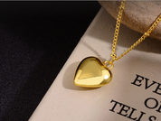 Gold heart pendant necklace on chain resting on book detail shot