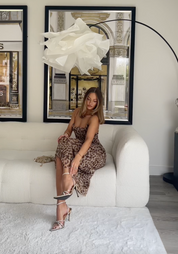 Leopard print dress seated on white couch