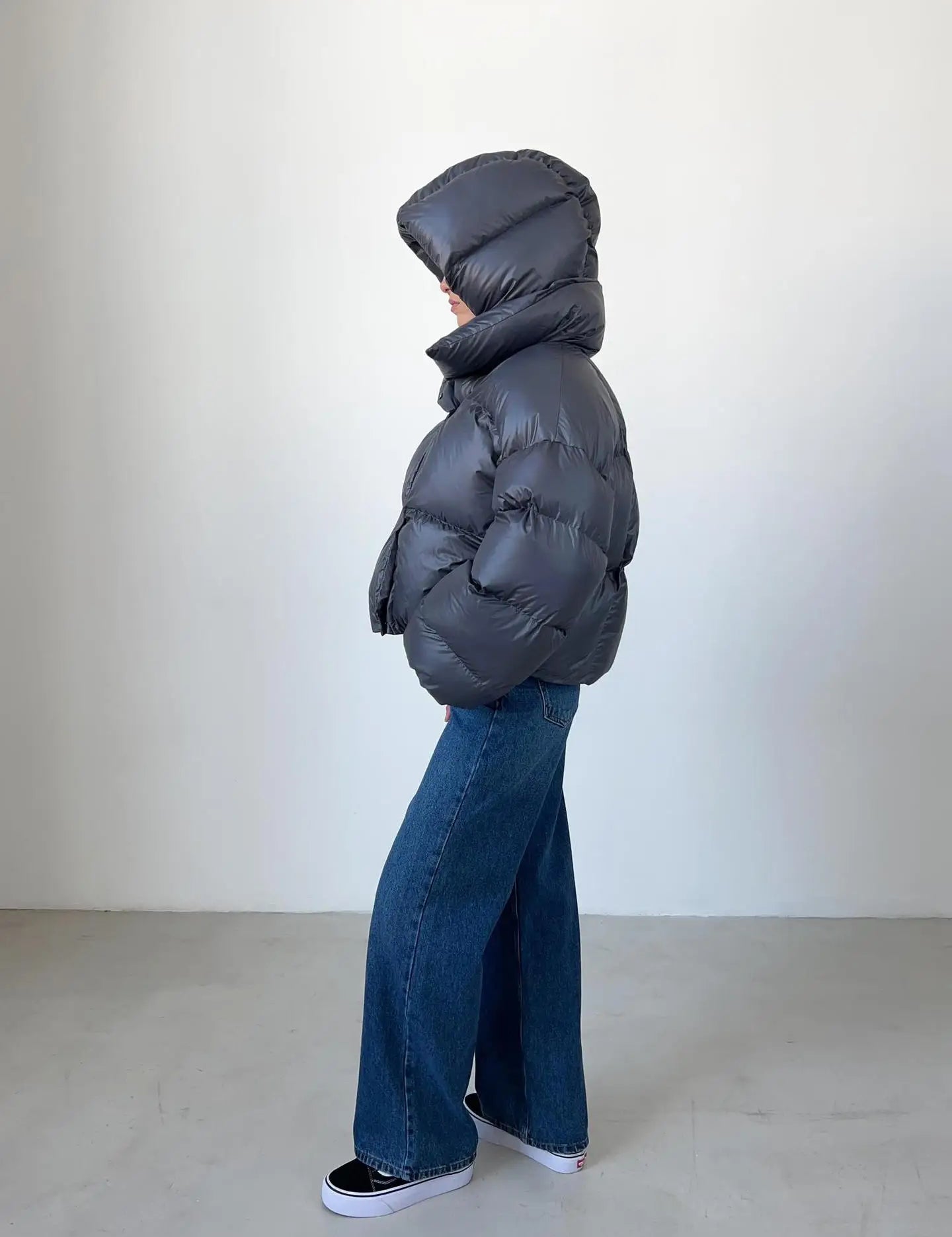 Oversized puffer jas donker grijs met capuchon, zij profiel