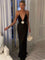 Black maxi dress with deep V-neck and white bow front view