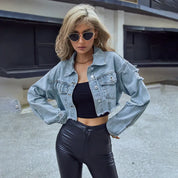 Light blue cropped denim jacket with distressed details three-quarter front view