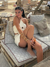 White crochet mini dress with floral pattern seated pose