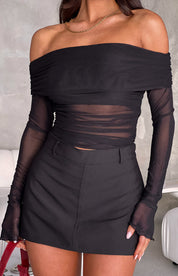 Black off-shoulder mesh top with sheer sleeves and skirt set front view with red bag