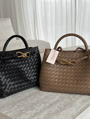 Handtas gevlochten zwart en beige met gouden details front view