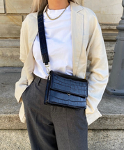 Black crocodile-print shoulder bag worn with outfit
