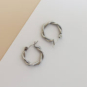 Silver hoop earrings with twisted design, angled view