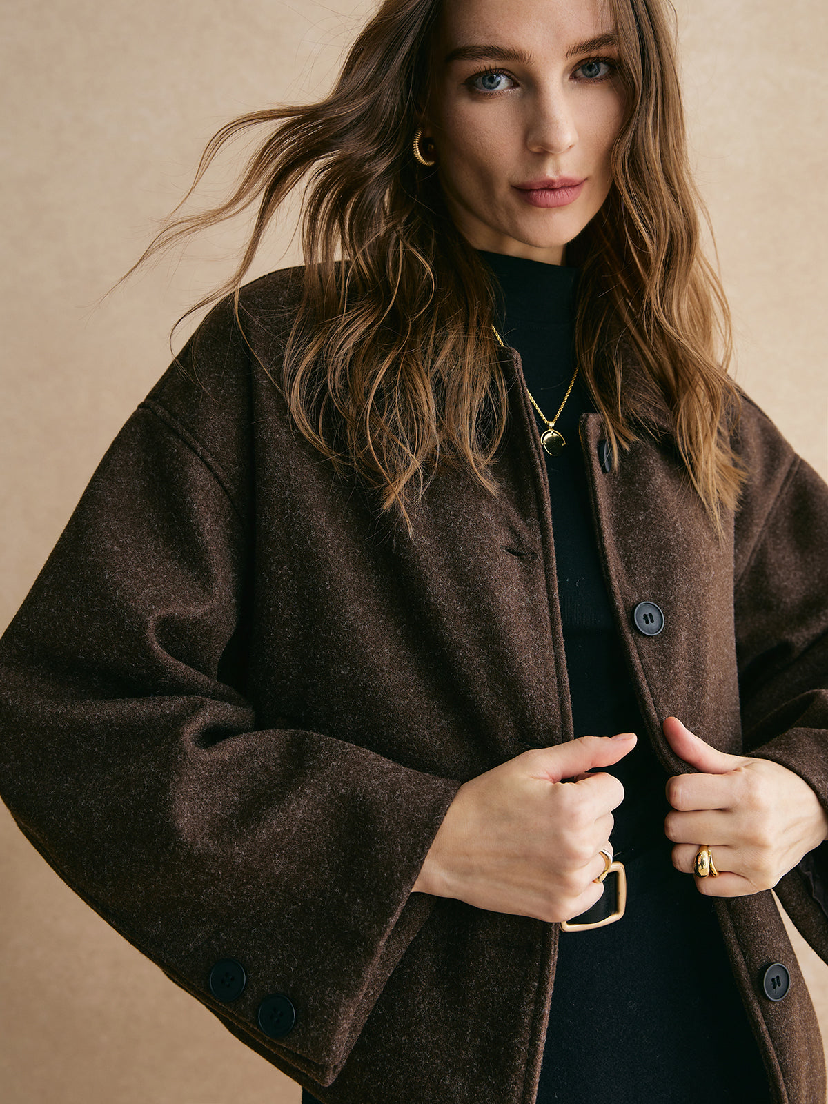 Brown blazer boxy fit close-up front view with model's hands on buttons