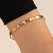 Gold armband with wave detail, side view