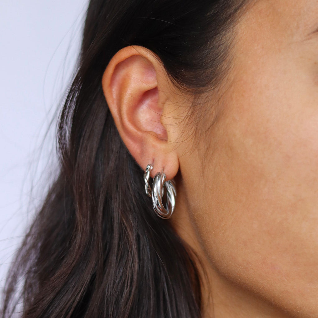 Silver hoop earrings worn on ear, side view