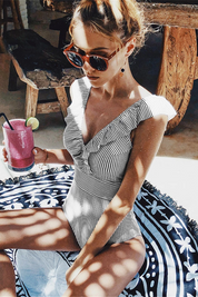 Badpak gestreept zwart-wit met V-hals en schouderband detail shot