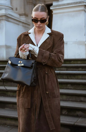 Brown suede trench coat front view with black bag