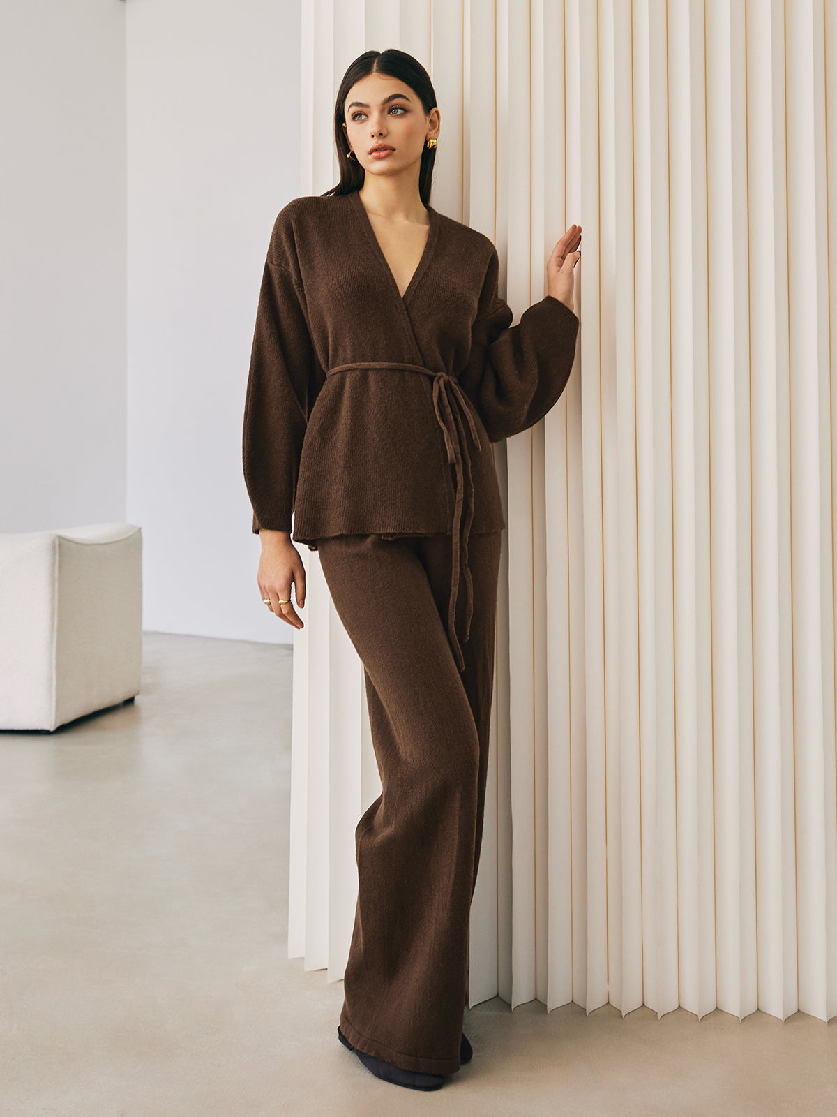 Brown knit wrap top and pants set, side view with hand on wall
