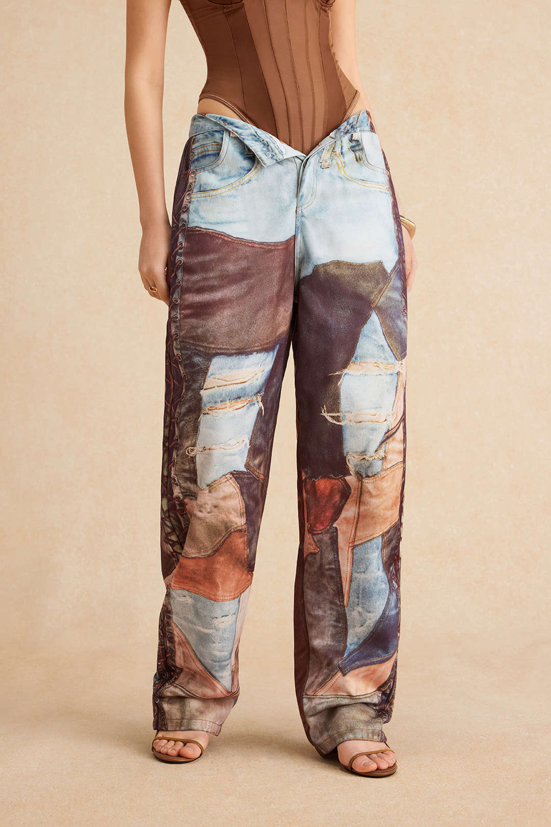Model wearing patchwork jeans with distressed details and brown top front view