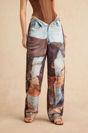 Model wearing patchwork jeans with distressed details and brown top front view