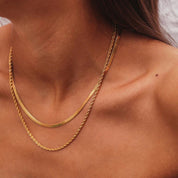 Gold-colored layered necklace on model angled view