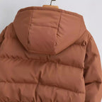 Brown puffer jacket with hood, close-up detail of chest