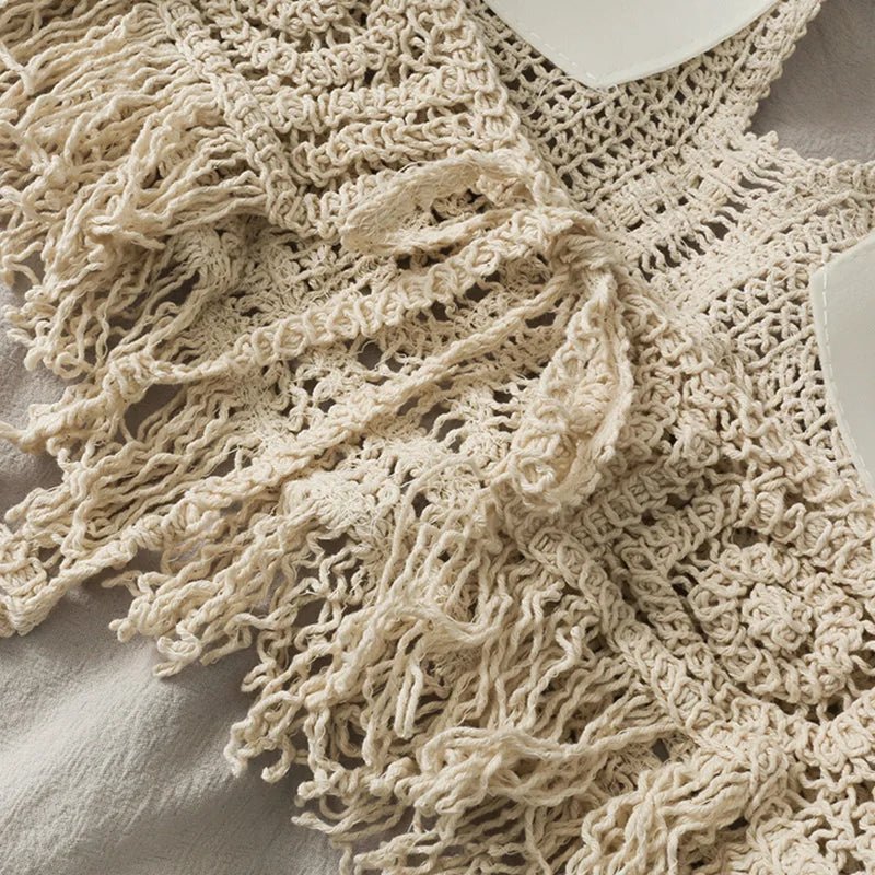 Close-up of cream crochet halter top with tassels, detailed view