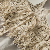 Close-up of cream crochet halter top with tassels, detailed view