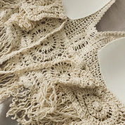 Cream crochet halter top with tassels, front close-up view