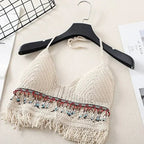 Cream crochet halter top with tassels and beaded trim, front view on hanger