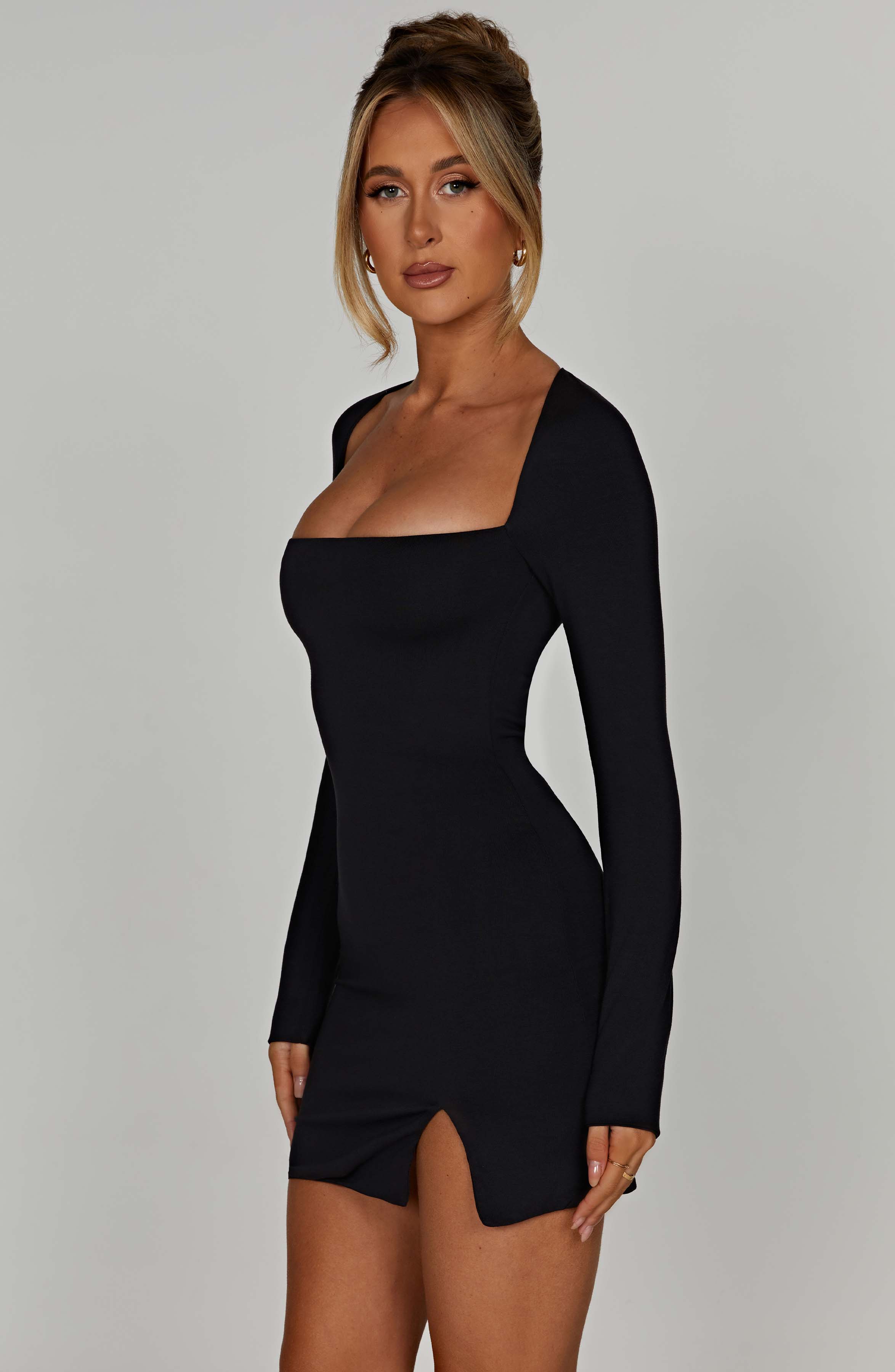 Black mini dress with square neckline and front side slit, side view