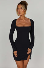 Black mini dress with square neckline and front side slit, side view with high heels