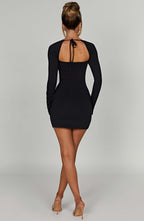 Black mini dress with square neckline and front side slit, back view with high heels